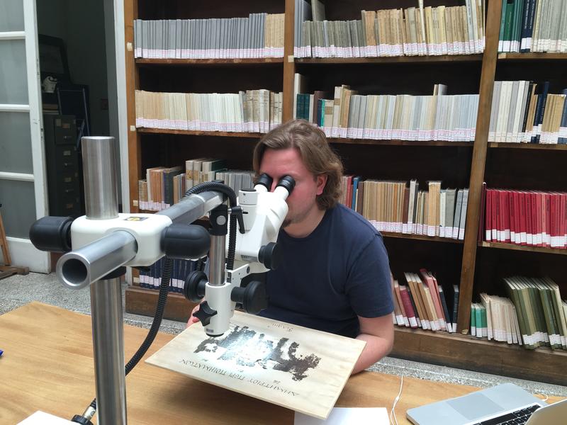 Dr Michael McOsker reading a papyrus